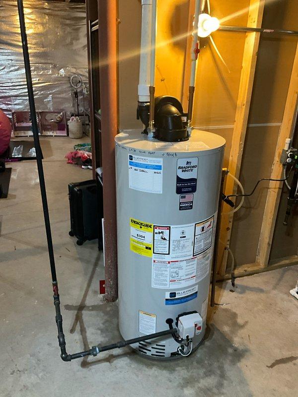 Installed a new 50-gallon power vent water heater in the basement utility area, including all necessary plumbing connections with copper piping and a black expansion tank. Protected the work area with drop cloths to maintain cleanliness throughout the installation process.