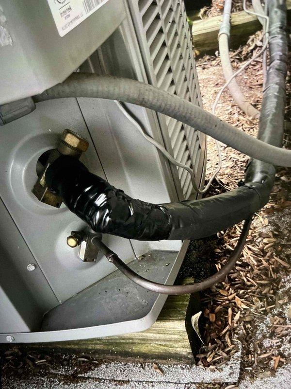 Completed installation of suction line insulation on residential HVAC system using Armorflex insulation material. Refrigerant lines were properly wrapped and secured at the outdoor condensing unit, ensuring proper thermal protection and system efficiency.