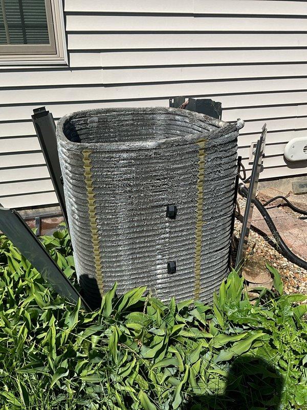 Completed comprehensive annual air conditioning maintenance at residential property. Performed full system inspection of outdoor condenser unit and indoor air handler components. Observed significant rust staining on concrete floor near air handler base and around PVC condensate drain line, indicating potential moisture concerns. Exterior condenser coils showed moderate accumulation of dirt, debris, and weathering with visible discoloration. Cleaned condenser coils, checked refrigerant levels, inspected electrical connections and wiring, verified proper drainage function, and tested system operation. Recommended monitoring condensate drain area for continued moisture issues and potential future maintenance of drain pan integrity.