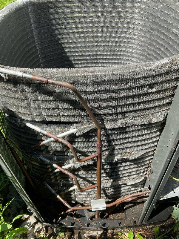 Completed comprehensive BFMA preventive maintenance tune-up on residential air conditioning system. Performed full system inspection of outdoor condenser unit, including evaluation of heat exchanger coils, refrigerant lines, and electrical connections. Documented equipment condition with photographic records showing cylindrical coil arrangement, copper line connections, and overall unit integrity for maintenance history files.