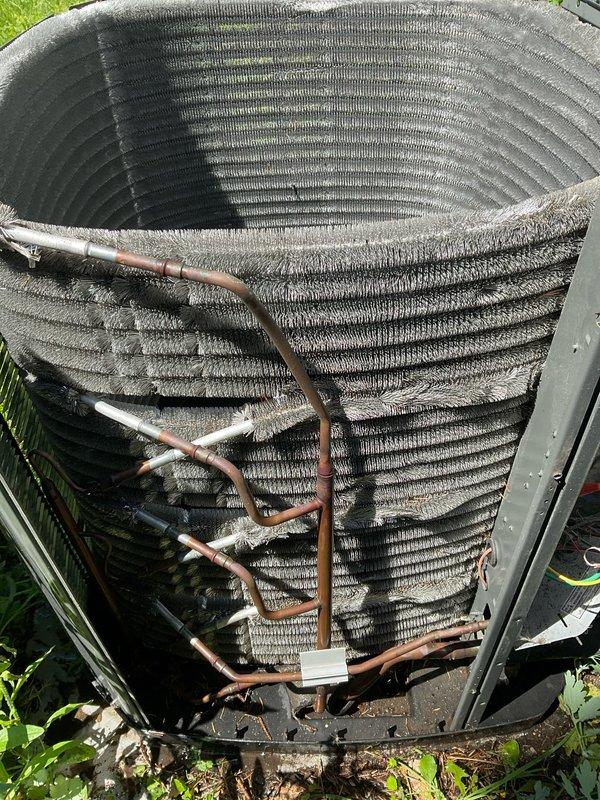 Completed comprehensive BFMA preventive maintenance tune-up on residential air conditioning system. Performed full system inspection of outdoor condenser unit, including evaluation of heat exchanger coils, refrigerant lines, and electrical connections. Documented equipment condition with photographic records showing cylindrical coil arrangement, copper line connections, and overall unit integrity for maintenance history files.