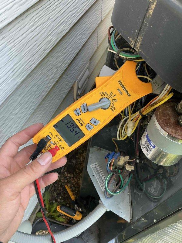 Responded to emergency service call for noisy air conditioning unit with same-day arrival before 10am. Upon arrival, performed comprehensive electrical diagnostics on outdoor condensing unit. Measured and recorded line voltage at 265.4V and control voltage at 24.53V using calibrated testing equipment. Inspected capacitor and electrical connections within component housing, finding all wiring bundles and terminals secure. Determined system electrical values within normal operating parameters. Unit operational at time of service with no immediate safety concerns identified.