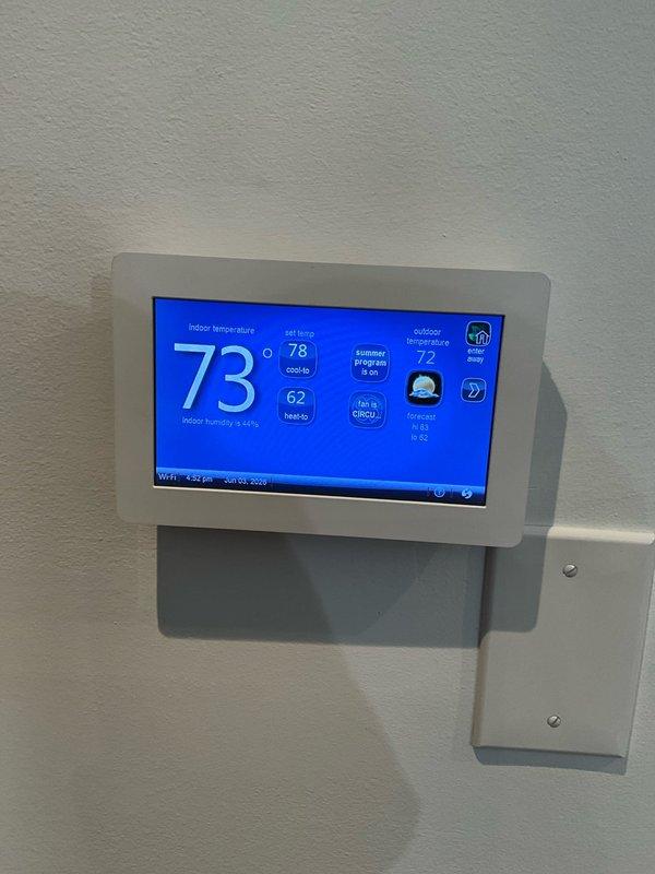 Completed comprehensive BFMA tune-up on 10+ year old air conditioning system during afternoon appointment window. Performed standard maintenance protocol including inspection of thermostat operation (currently set to cool to 62°F with actual indoor temperature at 73°F), verified system controls and WiFi connectivity functioning properly. Inspected outdoor condenser unit, noted accumulation of leaves, twigs, and debris in base pan around compressor; cleared debris from unit interior and verified all electrical connections and wiring harness secure. System operational upon completion of tune-up service.