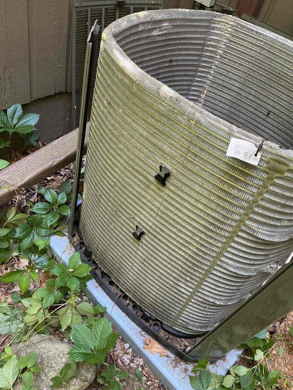 Completed comprehensive BFMA tune-up service on residential air conditioning system with equipment aged 1-3 years. Performed full inspection and maintenance of outdoor condenser unit, which showed significant organic debris accumulation including pollen, algae buildup on lower fin sections, and dried leaves within the unit housing. Cleaned condenser coils and fins to restore proper airflow and heat transfer efficiency, removed all organic debris from unit interior and surrounding base area, and verified proper operation of all system components. Unit restored to optimal operating condition with improved airflow and heat exchange capabilities.