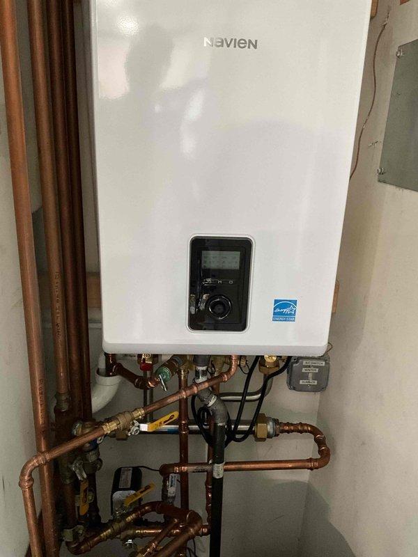 Completed warranty replacement of existing combi boiler with new Navien tankless water heater unit under approved manufacturer return authorization. Installation included proper mounting of the Energy Star certified unit, professional copper pipe configuration with multiple shut-off valves for maintenance access, electrical connections, and venting system integration to ensure optimal performance and code compliance.