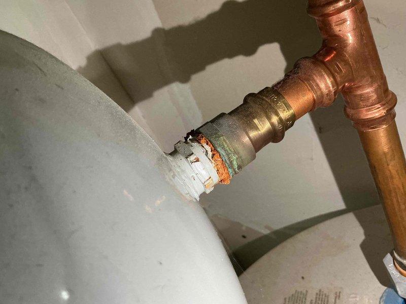 Completed comprehensive BFMA tune-up service on 7-year-old First Co. Aqua Therm heating system (Model 18HBOBX) and air conditioning unit with R-410A refrigerant. Performed standard maintenance procedures including filter inspection, electrical component testing, and system performance verification. Documented significant corrosion and deterioration at water heater connection point where copper piping joins brass fitting and white plastic component, requiring attention to prevent potential leak failure.