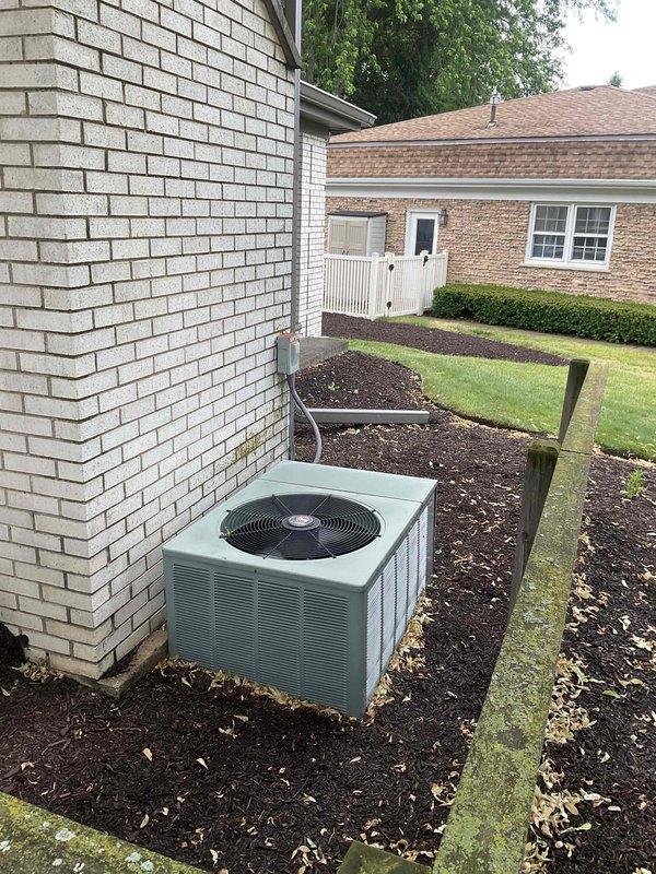 Completed full system estimate for residential HVAC replacement. Evaluated existing outdoor condensing unit located on exterior white brick wall in mulch bed, noting equipment condition and placement for replacement considerations. Inspected electrical service panel and documented breaker configuration, identifying vacant breaker slot that will require attention during new system installation. Assessed property layout, equipment accessibility, and electrical infrastructure to provide comprehensive replacement proposal for complete heating and cooling system.