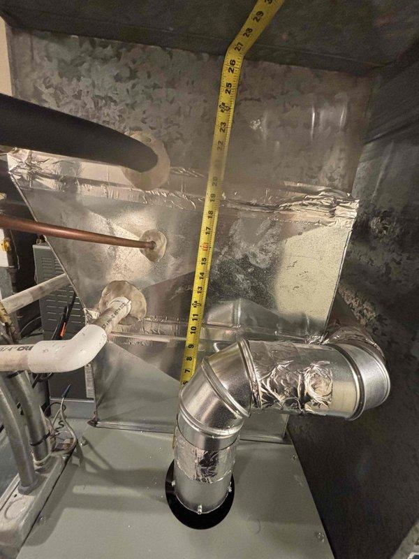 Responded to callback for A/C unit experiencing issues and water leakage following previous service visit. Performed diagnostic inspection of system components in attic installation space. Investigated condensate drain system and evaluated PVC drain line routing. Measured ductwork clearances and assessed flexible duct connections to identify potential moisture intrusion points. Documented HVAC system configuration and drainage assembly with detailed measurements to determine if current issues were related to prior service work or represented new system concerns.
