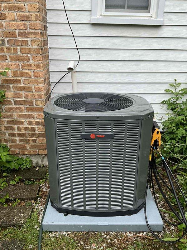Completed installation of Trane 3-ton air conditioning system including 5TTR6036A1000 condenser unit and 5PXCC005AS3HA evaporator coil. Installed P200 thermostat with company branding, mounted condenser on concrete pad with proper clearances, ran electrical conduit along exterior siding, and modified ductwork by adding 3-inch tee to intake plenum for improved airflow. System tested and operational upon completion.