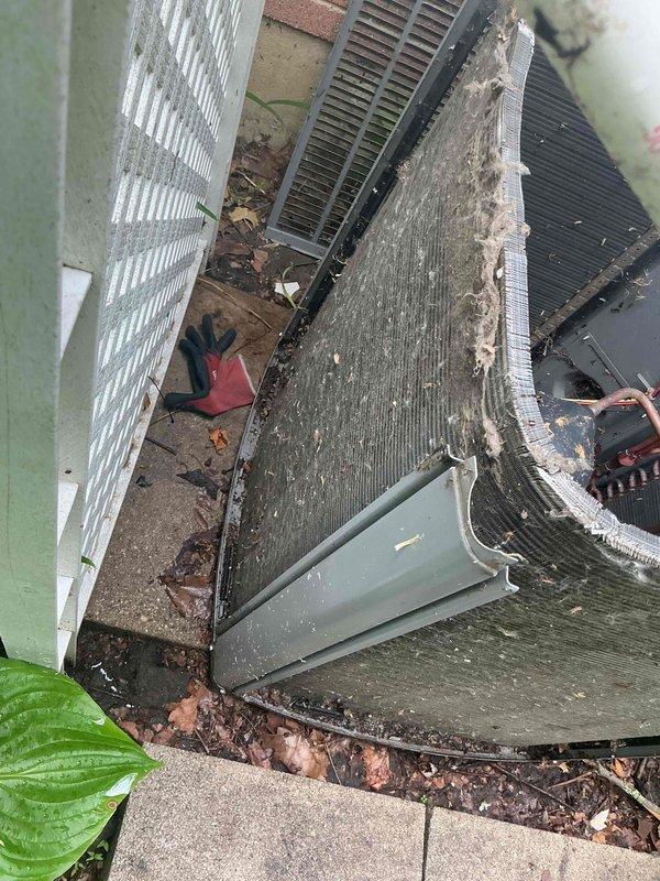 Completed comprehensive AC tune-up on 9+ year old outdoor condenser unit. Removed heavy accumulation of organic debris, decomposed leaves, and dirt from unit base, coils, and surrounding concrete pad. Cleaned condenser coils, inspected refrigerant lines, verified proper airflow through fins, and ensured unit operational efficiency following standard BFMA maintenance protocols.