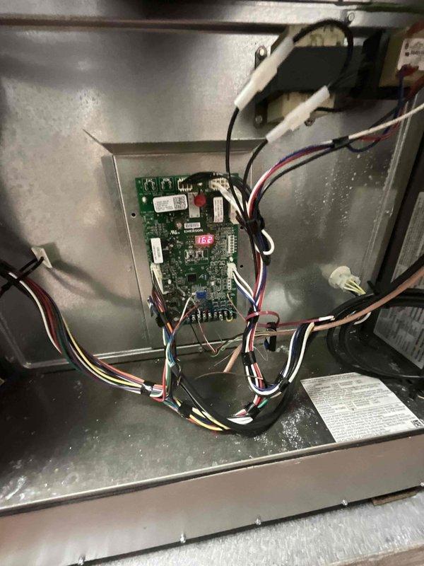 Completed comprehensive BFMA preventive maintenance tune-up on residential air conditioning system. Performed thorough inspection of control board, verified all electrical connections and wire harnesses, confirmed proper operation of digital display reading 165 degrees, and examined evaporator coil assembly. Inspected outdoor unit coil fins for debris accumulation, checked refrigerant lines and mounting brackets for secure connections, and documented system components with photographic records for maintenance history.