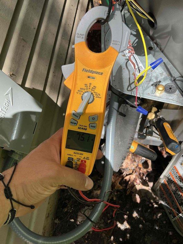 Responded to no cooling complaint where client reported blower operation but no cool air and inability to achieve temperatures below 77 degrees. Upon arrival, performed diagnostic testing using clamp meter to measure electrical parameters at the outdoor unit, revealing insufficient amperage draw indicating compressor failure to engage. Inspected electrical disconnect box and found loose wiring connections with disorganized wire management that had compromised system operation. Secured all electrical connections, verified proper voltage supply, and restored unit to normal cooling operation with compressor running at proper amperage.