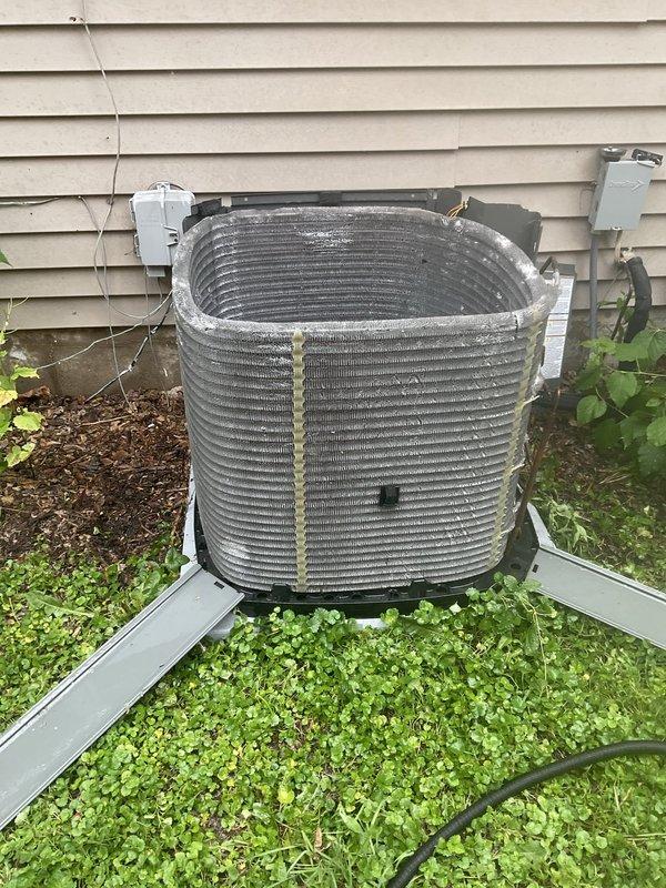 Completed comprehensive BFMA tune-up service on residential air conditioning system aged 3+ years. Performed standard maintenance protocol including inspection of outdoor condenser unit, which showed typical weathering and debris accumulation on coil fins consistent with outdoor exposure. Cleaned condenser coils to remove dirt, grime, and vegetation debris that had accumulated on horizontal ribbed fins and metal surfaces. Verified proper clearance around unit and addressed vegetation encroachment around base and sides of equipment. Inspected electrical disconnect, mounting hardware, and refrigerant lines for proper operation. System operating within normal parameters upon completion of tune-up service.