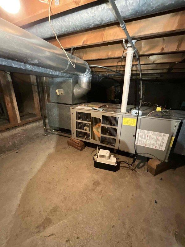 Completed full HVAC system installation consisting of a 3-ton ML13KC1-030 air conditioning condenser unit paired with a CK40HT-36B evaporator coil and an EL297UH070XV36BK 70,000 BTU 97% AFUE two-stage variable-speed furnace. Installed furnace in horizontal configuration within crawl space with proper clearances and venting, routing supply and return ductwork along ceiling joists with appropriate insulation and support strapping. Positioned outdoor condenser unit on concrete pad with proper clearances from structure, installed 30-amp fusible disconnect box with two 25-amp fuses, and ran refrigerant lines and electrical conduit to exterior wall penetration. Completed secondary refrigerant line run through horizontal crawl space as specified. Installed AA210 condensate management system and programmed 4235 thermostat for two-stage heating and cooling operation. Verified all electrical connections meet code requirements, tested system startup and operation, confirmed proper airflow and ref