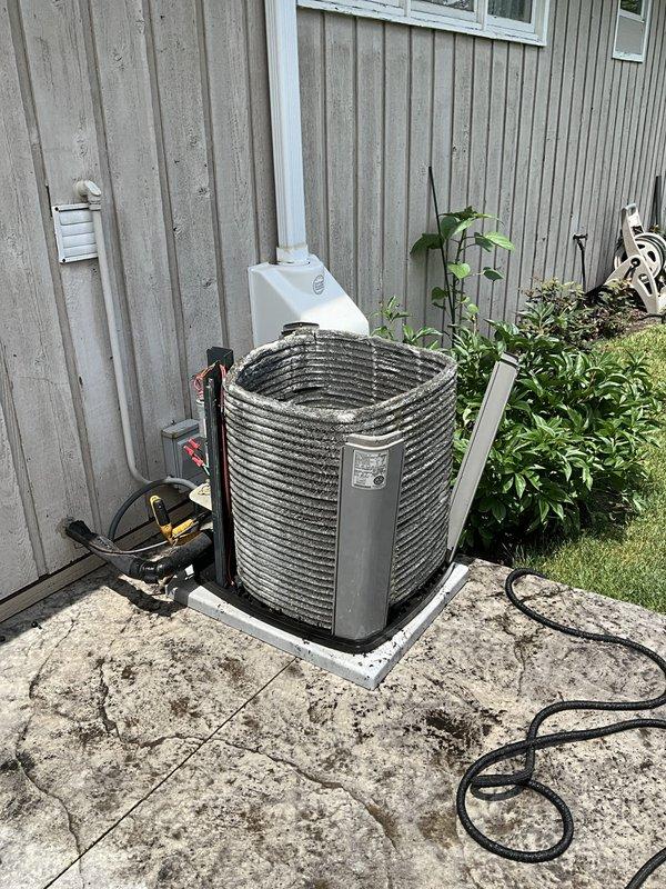 Completed comprehensive BFMA tune-up on a 21+ year old residential air conditioning system during afternoon service window. Performed standard maintenance protocol on outdoor condenser unit including inspection of compressor operation, refrigerant level verification, electrical connection evaluation, and coil cleaning of the cylindrical finned condenser positioned on weathered concrete pad. Inspected and serviced indoor air handler components including pleated air filter assessment, ductwork connections, and associated mechanical systems with water filtration equipment and copper piping infrastructure. All system components tested and confirmed operational following tune-up procedures, with equipment running within acceptable parameters despite advanced age of unit.