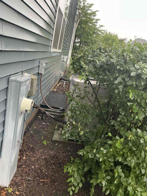 Conducted comprehensive assessment of residential HVAC system including 27-year-old air conditioning unit and 12-year-old furnace. Customer reported AC had recently frozen during operation and was shut down to defrost. Evaluated outdoor condensing unit mounted on platform with refrigerant lines, electrical disconnect, and mounting hardware. Inspected indoor air handler system with PVC condensate drainage and venting components. Documented existing equipment condition and configuration to provide replacement estimate for aging AC system and coil assembly due to advanced age and recent freezing issue indicating potential refrigerant or airflow concerns.