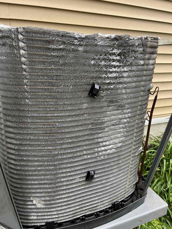 Completed comprehensive BFMA tune-up service on outdoor heat pump unit aged 3+ years. Performed standard AC maintenance protocol including inspection of condenser coil, refrigerant lines, and internal components. Upon inspection, identified significant deterioration of top protective covering with material breakdown and exposure of internal coil structure. Removed rear access panel to assess evaporator coil condition, verified copper refrigerant lines showed no visible leaks or damage, and inspected fin assembly which displayed normal weathering consistent with outdoor exposure. System operational at time of service completion.