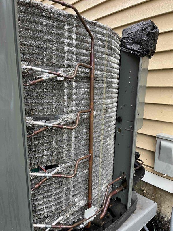 Completed comprehensive BFMA tune-up service on outdoor heat pump unit aged 3+ years. Performed standard AC maintenance protocol including inspection of condenser coil, refrigerant lines, and internal components. Upon inspection, identified significant deterioration of top protective covering with material breakdown and exposure of internal coil structure. Removed rear access panel to assess evaporator coil condition, verified copper refrigerant lines showed no visible leaks or damage, and inspected fin assembly which displayed normal weathering consistent with outdoor exposure. System operational at time of service completion.