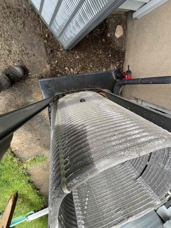 Completed comprehensive BFMA tune-up service on residential air conditioning system aged 4+ years. Performed thorough inspection of outdoor condenser unit, which exhibited heavy accumulation of dust, dirt, and debris throughout the cylindrical coil fins, significantly impacting airflow and heat transfer efficiency. Cleaned condenser coils to remove thick buildup from horizontal fin surfaces, restored proper airflow clearance, and verified refrigerant line connections and electrical conduit integrity. System operational and ready for continued service.
