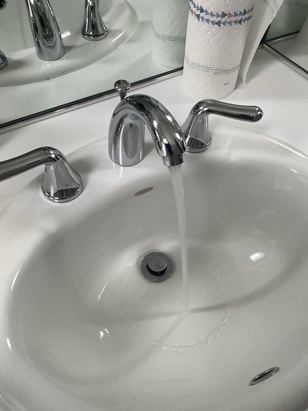 Completed comprehensive plumbing inspection as part of scheduled maintenance tune-up service. Inspected bathroom vanity fixtures including widespread chrome faucet assembly with lever handles and oval porcelain sink basin, confirming proper operation of drain stopper and overflow system. All plumbing fixtures found to be in good working condition with no leaks or deficiencies noted.