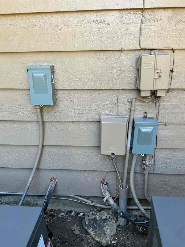 Replaced two AC disconnect switches at the outdoor unit location. Performed electrical testing with clamp meter to verify proper system operation and confirm zero amperage draw during disconnect replacement. Installation included proper conduit routing and weatherproof enclosures mounted to exterior wall, with all electrical connections secured according to code requirements.