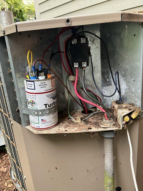 Responded to after hours no cooling call on aging HVAC system affecting first level. Upon arrival, confirmed outdoor unit condenser fan motor operational but noted extremely hot refrigerant line indicating potential compressor failure or refrigerant system issue. Performed visual inspection of outdoor unit electrical compartment, documenting condition of capacitor, contactor, and condenser fan motor. Unit shows significant age with corrosion on mounting brackets and electrical components. Captured diagnostic photos of electrical components and motor specifications for assessment. Advised client of findings and discussed options for repair versus replacement given age and condition of equipment.