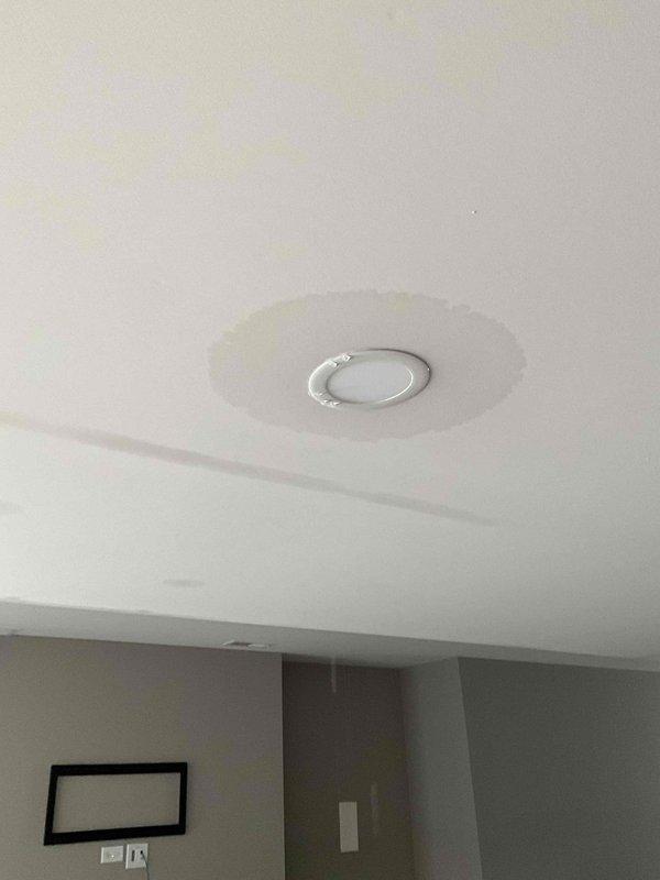 Responded to after hours call for ceiling damage assessment. Upon arrival, documented visible vertical crack where ceiling meets wall near HVAC/plumbing conduit and access panel, indicating possible structural settling. Also identified and photographed ceiling-mounted smoke detector with significant circular water staining and discoloration surrounding the unit, suggesting active or previous moisture intrusion from above. Recommended follow-up inspection to determine water source and assess extent of damage requiring repair.