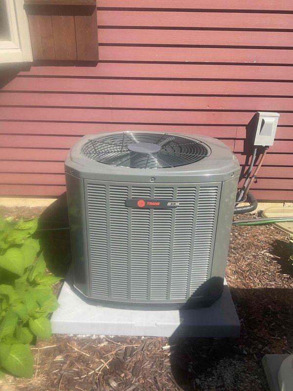Completed comprehensive BFMA tune-up service on a Trane outdoor condensing unit approximately 2+ years old. Performed full system inspection including cleaning condenser coils, checking refrigerant levels, testing electrical connections at disconnect box, inspecting fan motor operation, verifying proper airflow through louvered panels, and confirming unit operation on concrete pad. All components found operating within manufacturer specifications with no immediate repairs required.