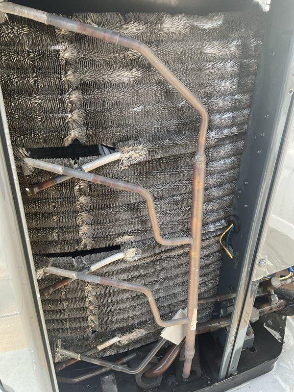 Completed comprehensive BFMA tune-up service on an 8-year-old air conditioning system. Performed thorough inspection of evaporator coil assembly, which showed significant accumulation of dirt and debris restricting airflow between aluminum fins. Inspected refrigerant lines including copper tubing with visible oxidation patina, verified secure mounting of all lines and connections, and examined electrical components. System was evaluated for operational efficiency, with coil condition documented showing need for cleaning to restore optimal airflow and performance.