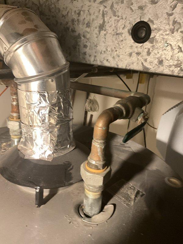 Completed installation of 75-gallon tanked water heater in basement utility area. Initial unit was damaged at the top upon delivery and required return to Ferguson for replacement. Successfully installed replacement unit with proper copper piping connections, secured all water supply lines, and verified system operation with no leaks detected.