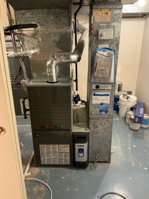 Completed full HVAC system installation in basement utility area, replacing existing equipment with Trane 6/16 SL280 two-stage variable speed furnace and EL15 single-stage air conditioner, upgraded to 16 SEER efficiency rating. Installed all necessary ductwork connections with metallic silver transitions and elbow joints from furnace unit. Connected electrical wiring and mounted control components on concrete block wall. Applied Lennox instant rebate program and included complimentary water heater installation as part of system upgrade package. Verified all mechanical connections, tested system operation for proper heating and cooling cycles, and confirmed variable speed blower motor functionality. All equipment installed to manufacturer specifications with proper clearances maintained around furnace unit and associated components.