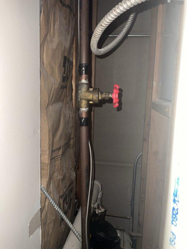 Completed comprehensive plumbing inspection as part of maintenance tune-up service, scheduled for afternoon arrival per customer request. Inspected interior plumbing system including copper supply lines with brass shut-off valve and red handle control mechanism in wall cavity, verified proper operation and checked for leaks. Examined bathroom plumbing fixtures including toilet, shower valve assembly, and associated water supply connections to ensure all components functioning properly with no visible issues detected.