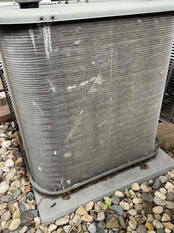 Completed comprehensive BFMA tune-up service on outdoor air conditioning condenser unit aged 6+ years. Inspected condenser coils and heat exchanger fins for proper operation, checked unit mounted on concrete pad with surrounding landscape rock, and replaced indoor air filter with clean pleated media filter to ensure optimal airflow and system efficiency.
