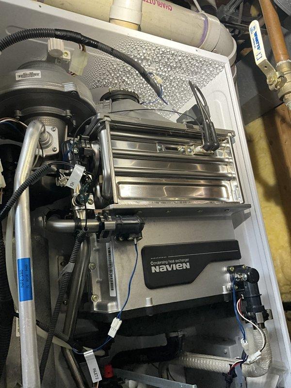 Responded to recurring water leak on 5-year-old Navien tankless water heater unit. Performed comprehensive inspection of heat exchanger, circulation pump connections, PVC condensate drain lines, and copper supply/return piping. Identified source of leak at previous repair location, tightened all plumbing connections, inspected internal components including blower assembly and control module for moisture damage, verified proper operation of pressure relief valve and isolation valves. System tested at operating temperature, confirmed no active leaks present, unit functioning within normal parameters.