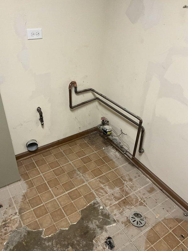 Shut off main water supply and drained entire plumbing system to prepare work area. Removed existing water softener from utility room and installed new 3-valve bypass assembly with proper copper connections. Drained and disconnected existing tanked water heater, then relocated both units to garage for temporary storage during flooring replacement. Upon completion of new tile flooring installation, returned to site and reinstalled water heater with all supply lines, pressure relief valve, and drain connections. Reinstalled water softener with bypass system and verified proper valve operation. Restored water supply to home and tested both units for leaks, proper water flow, and operational functionality. All connections secured and system returned to full service with 1-year labor warranty provided.