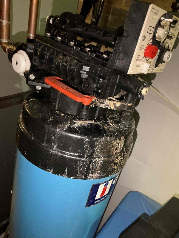 Completed comprehensive BFMA tune-up on residential air conditioning system with 4+ year old equipment. Inspected outdoor condenser unit, noting dirt and debris accumulation on coil fins requiring attention, and verified refrigerant line connections. Inspected indoor mechanical components including water heater assembly with visible mineral deposit buildup on mounting surfaces, checked electrical connections and control panel functionality, and documented equipment condition with photos for maintenance records.