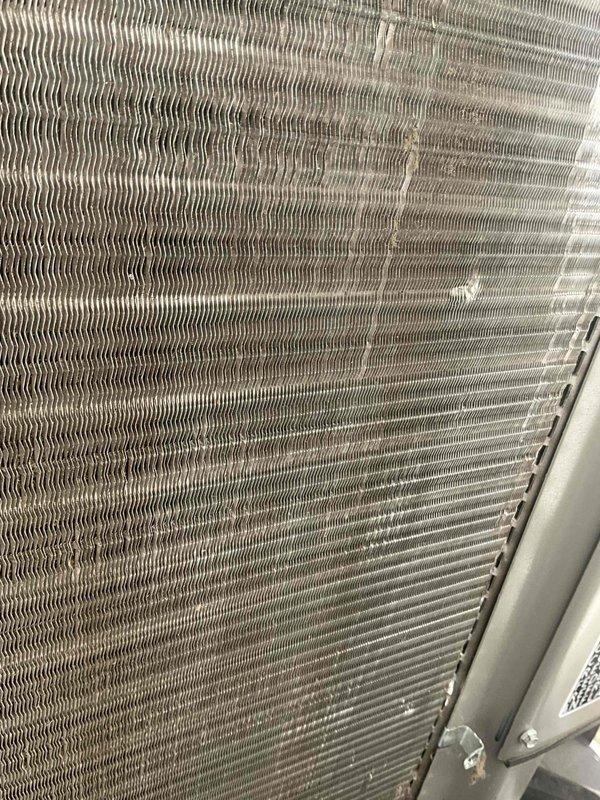 Completed comprehensive BFMA tune-up service on residential air conditioning system with equipment age of 8+ months. Performed standard AC maintenance protocol including inspection of condenser coil assembly, which revealed moderate accumulation of dust and debris between metallic fins requiring attention. Documented current condition of heat exchanger surfaces showing dirt buildup and discoloration across coil face, particularly in central sections, which can impact heat transfer efficiency if left unaddressed. Inspected exterior housing, mounting frame, and connected flexible conduit for proper installation and secure connections. All components assessed and system evaluated for optimal performance per BFMA maintenance standards.
