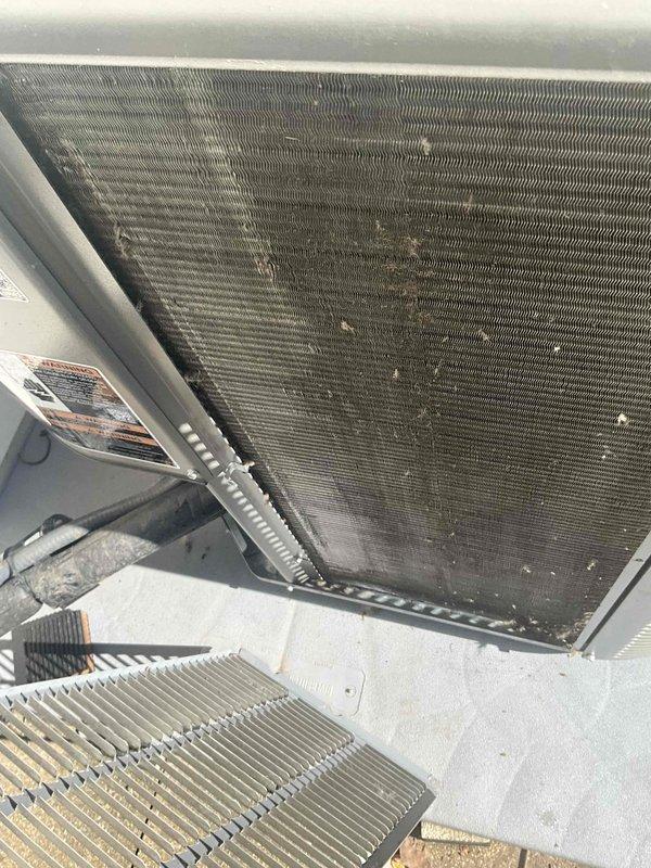 Completed comprehensive BFMA tune-up service on residential air conditioning system with equipment age of 8+ months. Performed standard AC maintenance protocol including inspection of condenser coil assembly, which revealed moderate accumulation of dust and debris between metallic fins requiring attention. Documented current condition of heat exchanger surfaces showing dirt buildup and discoloration across coil face, particularly in central sections, which can impact heat transfer efficiency if left unaddressed. Inspected exterior housing, mounting frame, and connected flexible conduit for proper installation and secure connections. All components assessed and system evaluated for optimal performance per BFMA maintenance standards.