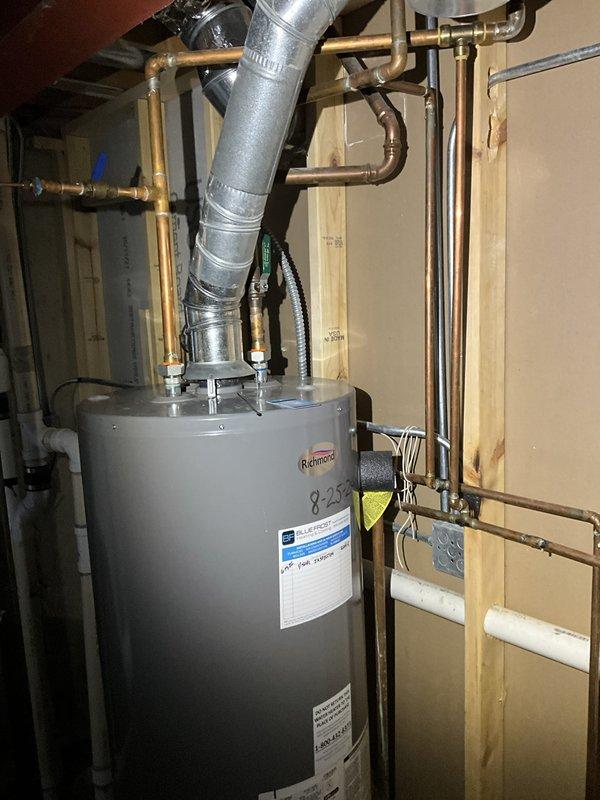 Completed comprehensive plumbing inspection of residential water heater system and associated piping infrastructure. Inspection included evaluation of Richmond water heater unit, copper supply and discharge lines, PVC drainage system, pressure relief valve operation, and all visible plumbing connections. HVAC system inspection was also performed during this service visit, with pressure testing conducted on refrigeration lines as evidenced by gauge readings on brass valve fittings.