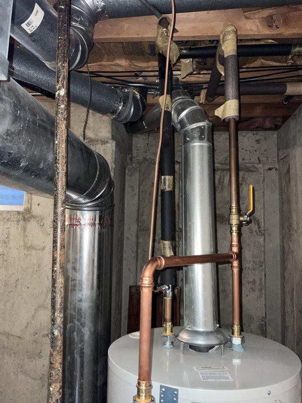 Responded to service call regarding recently installed water heater with excessive heat buildup in overhead piping. Upon inspection, identified cooling fan installed with incorrect orientation, directing airflow away from hot water pipes rather than providing adequate cooling. Verified water heater operation and pilot light function. Confirmed all copper supply lines, brass valves, and connections properly installed per code. Repositioned cooling fan to correct direction to properly ventilate hot water distribution piping and prevent excessive heat accumulation in confined basement mechanical space. Tested system operation to ensure adequate air circulation around piping. All components functioning as designed following fan repositioning.