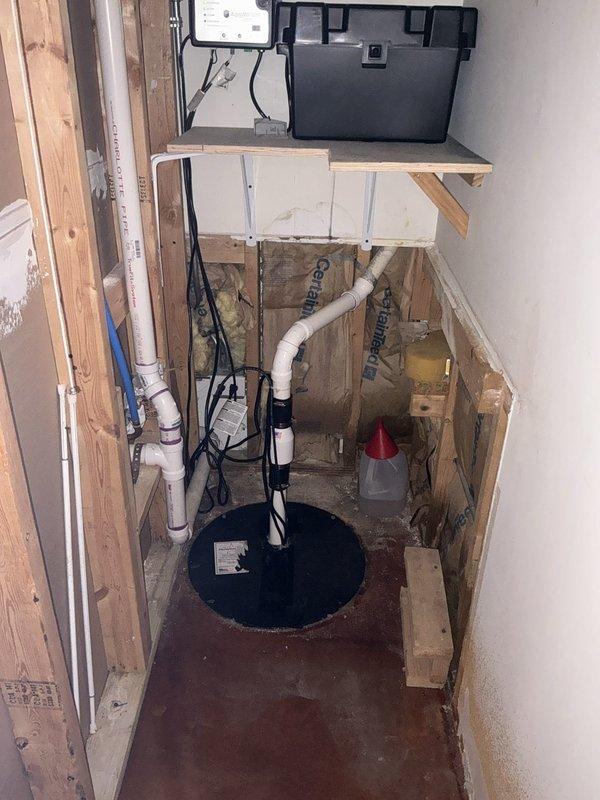 Completed comprehensive plumbing inspection of residential property, examining sump pump installation in basement utility area and verifying proper connections and functionality of drainage system. Inspected bathroom sink plumbing fixtures, confirming angle stop valves, flexible supply lines, and drain connections are secure and operating without leaks.