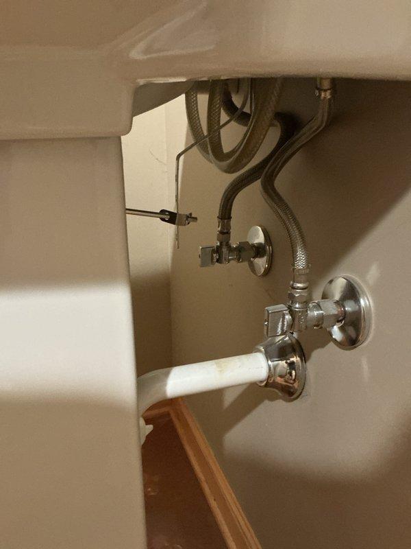 Completed comprehensive plumbing inspection of residential property, examining sump pump installation in basement utility area and verifying proper connections and functionality of drainage system. Inspected bathroom sink plumbing fixtures, confirming angle stop valves, flexible supply lines, and drain connections are secure and operating without leaks.