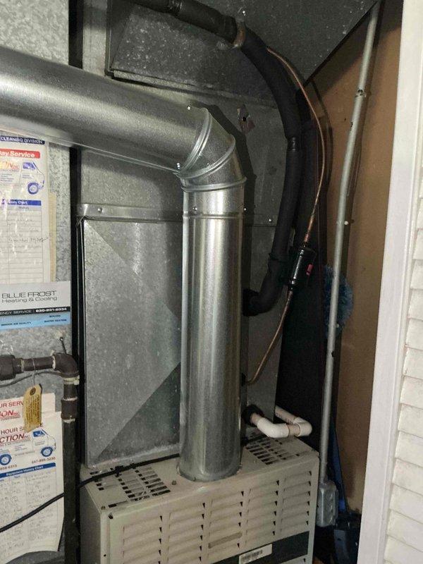 Evaluated existing HVAC system consisting of a 30+ year old Carrier WeatherMaker furnace and 10+ year old air conditioning unit in residential utility closet. Both systems currently operational but have exceeded their effective service life and require replacement. Inspected existing 1/4" refrigerant line set and determined complete replacement necessary due to age and improper sizing for new equipment installation. Noted drop ceiling configuration in installation area which will facilitate line set replacement process. Documented current equipment configuration including furnace unit, ductwork connections, water heater proximity, and electrical/refrigerant line routing. Photographed existing installation showing furnace with vertical duct extension, condensate drainage system, and mechanical room layout. Prepared comprehensive full system replacement estimate for new furnace and air conditioning unit with properly sized refrigerant lines to restore optimal heating and cooling efficien