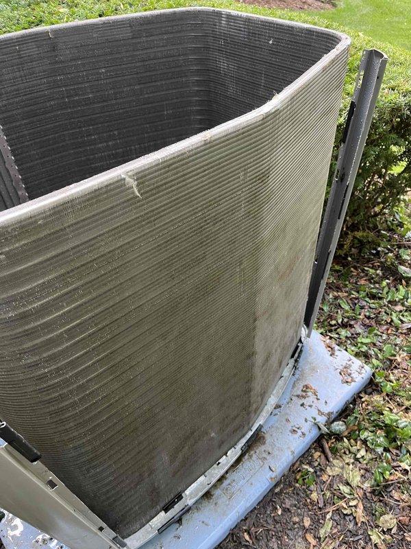 Completed comprehensive BFMA tune-up service on residential air conditioning system aged 1+ years. Performed standard maintenance protocol including inspection of outdoor condenser unit, which revealed significant accumulation of dirt, dust, pollen, and organic debris on exterior coil fins requiring cleaning. Cleaned condenser coils to restore proper airflow and heat transfer efficiency, verified unit operation, and documented equipment condition with photographic evidence for service records.