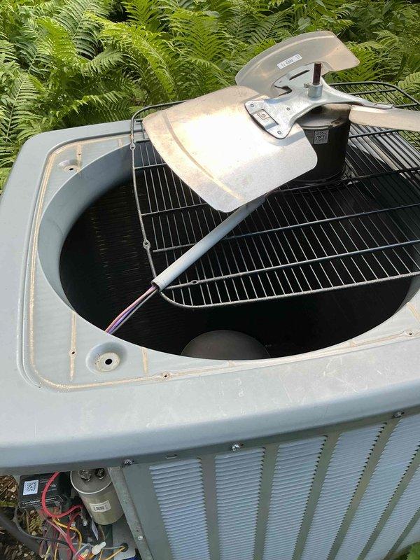 Performed comprehensive BFMA tune-up on 10+ year old residential air conditioning system. Removed condenser top panel to access and inspect internal components including fan assembly, electrical connections, and capacitor with visible wiring. Utilized Fieldpiece SC440 clamp meter to measure electrical parameters on refrigerant lines, recording readings of 10.15 and 0.3 to verify proper system operation and performance.