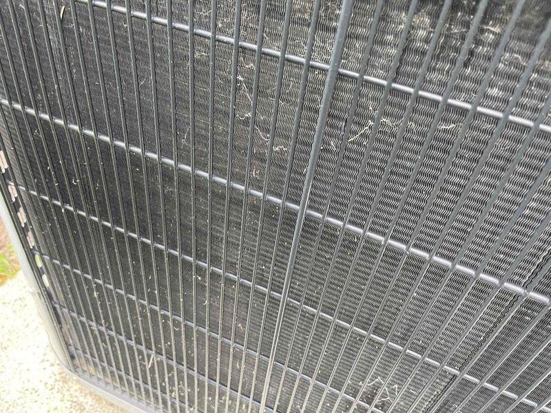Completed comprehensive BFMA tune-up on a 7+ year old air conditioning system. Inspected indoor air filter showing moderate dust accumulation and discoloration, indicating normal usage since last service. Examined outdoor condenser unit, verifying proper clearance, inspecting coil fins and protective grille for debris and environmental wear, with all components functioning within normal parameters.