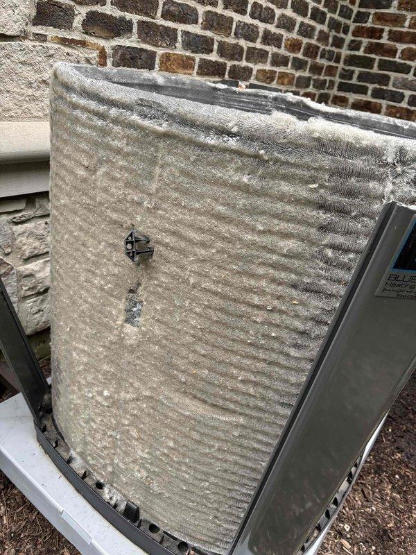 Completed comprehensive BFMA tune-up service on four air conditioning units at the property. During inspection, documented severe coil corrosion and fin deterioration on exterior condenser unit, with extensive white and gray oxidation buildup, bent fins, and physical damage to the coil structure indicating long-term environmental exposure. Also identified heavy dust and lint accumulation on blower assembly components, with fibrous debris creating significant buildup patterns across cylindrical ductwork and mechanical components. Performed standard maintenance procedures including system evaluation, visual inspection, and photographic documentation of equipment condition to establish baseline for future service recommendations and potential component replacement needs.