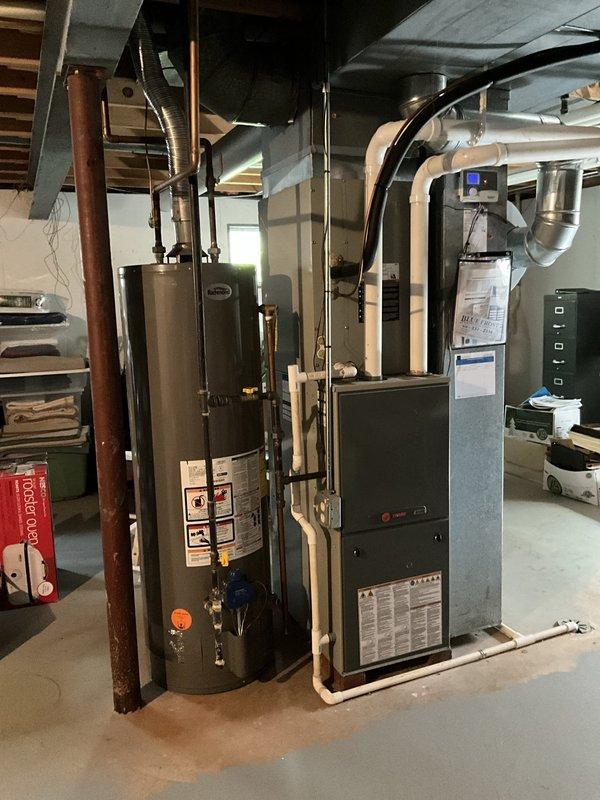 Completed comprehensive HVAC system evaluation for full system replacement estimate in residential basement utility area. Documented existing furnace, water heater, and ductwork configuration including current equipment specifications, installation layout, and spatial requirements for proposed system upgrade.