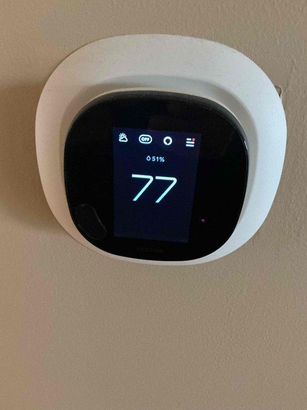 Completed comprehensive BFMA tune-up service on residential air conditioning system over 5 years old. Performed standard maintenance protocol including inspection of outdoor condenser unit, verification of thermostat operation displaying 77°F setpoint, and assessment of system components. Unit operational with no immediate issues identified; noted vegetation growth around condenser base requiring monitoring to ensure adequate airflow clearance.