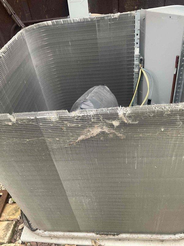 Completed comprehensive BFMA tune-up service on two residential air conditioning systems, both approximately 15 years old. Performed standard preventive maintenance procedures including inspection of outdoor condenser units, which revealed moderate fin damage and deterioration along the top coil sections with accumulated debris throughout the heat exchanger surfaces. Cleaned condenser coils, checked electrical connections and wiring, verified refrigerant levels, tested system operation and performance, and documented equipment condition with photographic evidence showing weathered components and protective mesh screening on exterior units mounted on brick paver patio.